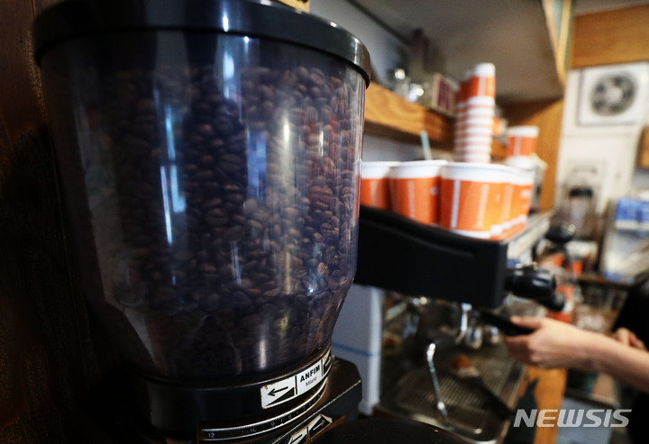 [서울=뉴시스] 백동현 기자 = 커피 원두 가격이 오를 것으로 예상되는 28일 오전 서울 시내 한 카페에서 가게 주인이 커피를 만들고 있다. 2021.09.28. livertrent@newsis.com