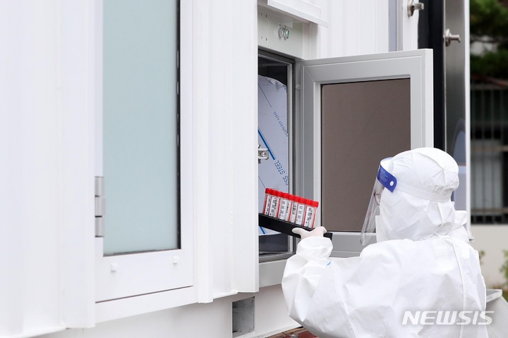 [서울=뉴시스] 사진공동취재단 = 28일 오전 '신속 자가분자진단 유전자증폭(신속 PCR)' 검사소가 마련된 서울 종로구 동성고등학교에서 의료진이 학생들에게 채취한 검체를 검사소 바로 옆에 위치한 이동형 검사실로 옮기고 있다. 서울시교육청은 '교육시설 이동검체팀'을 1개팀에서 4개 팀 이상으로 확대하고, 기숙사 운영 학교 5개교를 대상으로 신속 PCR 검사를 시범 운영하는 등 다음 달 6일까지 '다중적 방역 집중 기간'으로 지정했다. 2021.09.28. photo@newsis.com