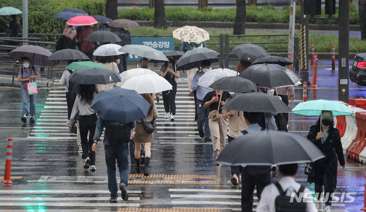 [서울=뉴시스] 김병문 기자 = 가을비가 내리는 지난달 29일 오전 서울 중구 서울역 인근에서 시민들이 우산을 쓰고 횡단보도를 건너고 있다. 2021.09.29. dadazon@newsis.com