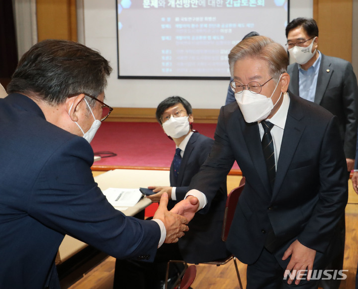 [서울=뉴시스] 국회사진기자단 = 더불어민주당 대선 예비후보인 이재명 경기도지사가 29일 오전 서울 영등포구 중앙보훈회관에서 열린 개발이익 환수제도의 문제와 개선방안에 대한 긴급토론회에서 참석자들과 인사를 하고 있다. 2021.09.29. photo@newsis.com