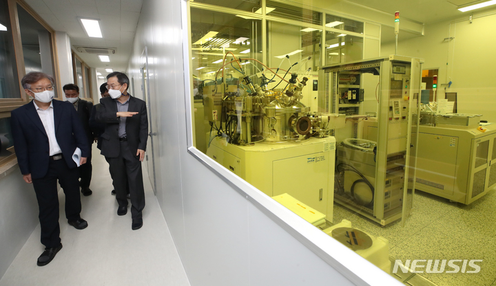 [서울=뉴시스] 조수정 기자 = 권칠승(왼쪽) 중소벤처기업부 장관이 29일 오전 시스템반도체 개발기업 팹리스(Fabless)와의 토론회를 위해 서울 관악구 서울대학교 관악캠퍼스 반도체공동연구소를 방문, 이종호(왼쪽 두번째) 반도체공동연구소장의 설명을 들으며 반도체 제조 시설인 팹(FAB)을 둘러보고 있다. 2021.09.29. chocrystal@newsis.com