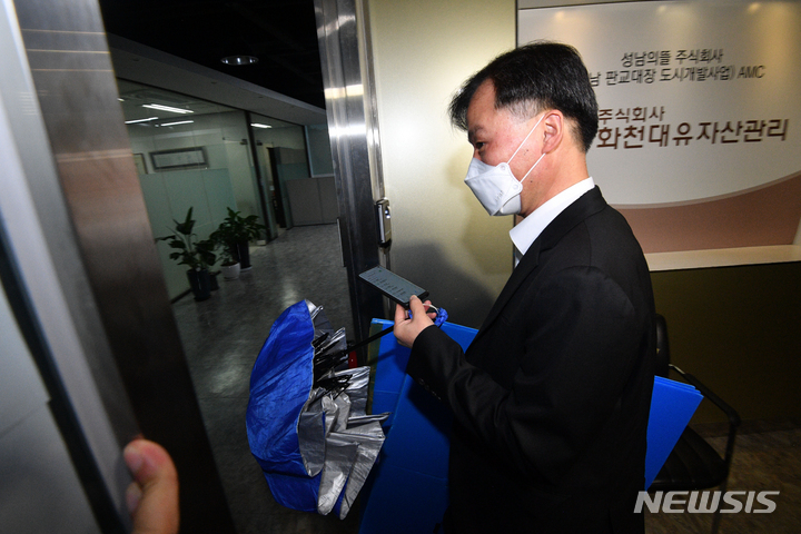 [성남=뉴시스] 김종택기자 = 지난달 29일 오후 경기도 성남시 자산관리사 화천대유 사무실에서 검찰 관계자가 압수품을 옮길 박스를 들고 들어가고 있다. (공동취재사진) 2021.09.29. jtk@newsis.com