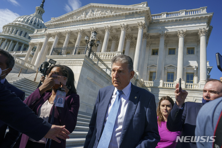 [워싱턴=AP/뉴시스]3조5000억 달러 규모 사회복지성 지출 법안 통과 키를 쥔 조 맨친 민주당 상원의원이 29일(현지시간) 의회 앞에서 기자들에 둘러싸인 모습. 2021.09.29.