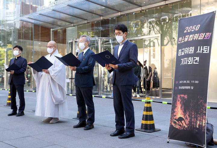 [서울=뉴시스] 고승민 기자 = 2050 탄소중립위원회 종교 위원들이 지난달 30일 서울 광화문 탄소중립위원회가 입주한 빌딩 앞에서 종교위원 사퇴 기자회견을 열고 사퇴문을 읽고 있다. 왼쪽부터 백종연 신부를 대신해 참석한 양기석 신부, 법만 스님, 안홍택 목사, 김선명 원불교 교무. 지난 5월부터 4개월간 활동한 이들은 위원회 구성과 회의내용 공개 등 소통 문제를 지적해 오다 지난 24일 2차 워크숍을 앞두고 상향된 2030 NDC 안과 2050 탄소중립시나리오를 만들라고 촉구했지만 받아들여지지 않자 사퇴에 뜻을 모았다. 2021.09.30. kkssmm99@newsis.com