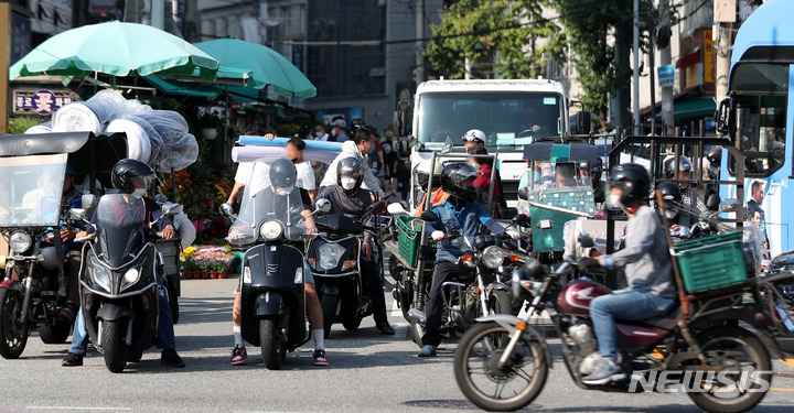 [서울=뉴시스] 추상철 기자 = 지난해 9월30일 오후 서울 종로구 동대문종합시장 인근에서 배달 종사자가 각종 물품을 배달하고 있는 모습. 2021.09.30. scchoo@newsis.com