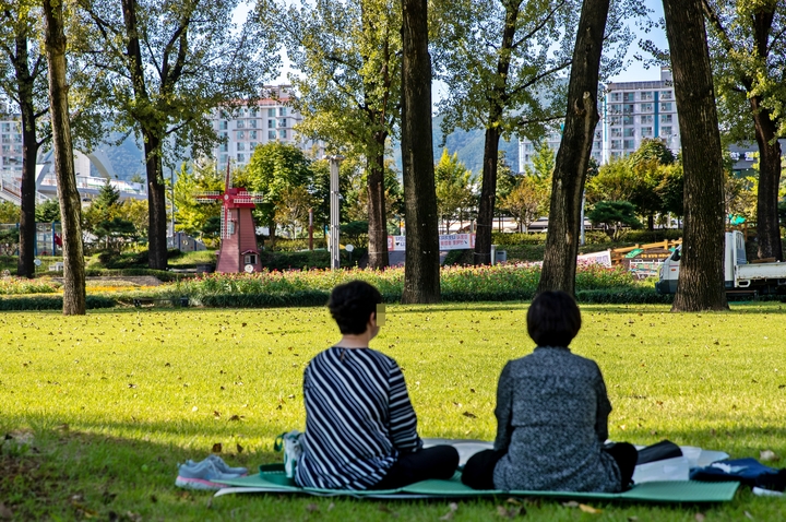 [증평=뉴시스] 강신욱 기자 = 충북 증평군이 도심 최고 쉼터인 보강천 미루나무숲 잔디밭을 1일 개방한 가운데 주민들이 잔디밭에 앉아 휴식을 취하고 있다. (사진=증평군 제공) 2021.10.01.&nbsp; *재판매 및 DB 금지