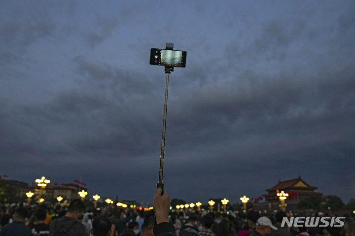 [베이징=AP/뉴시스] 지난 1일 중국 베이징에서 톈안먼광장에서 국기게양식을 기다리면 한 남성이 셀카봉을 들고 있다. 2021.10.02