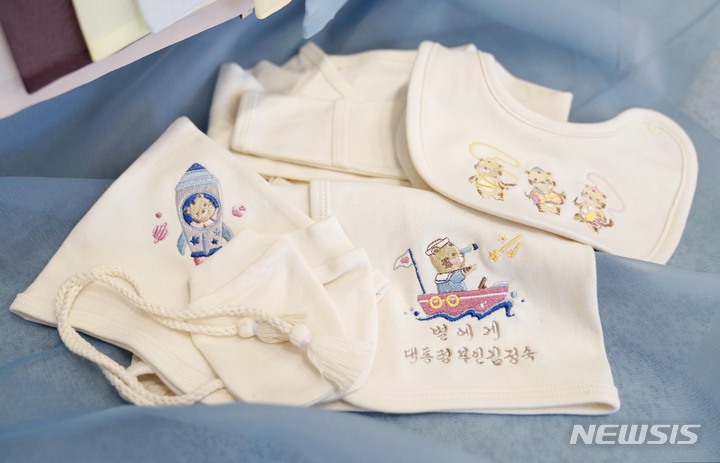 [포항=뉴시스] 김진아 기자 = 김정숙 여사가 국군의 날인 1일 오후 경북 포항 해병대1사단 부대에서 열린 장병 격려 오찬 참석자 중 셋째 자녀 임신 소식을 알린 한 해병 대위에게 태명을 수놓은 배냇저고리를 선물하고 있다. 사진은 김 여사가 선물한 배냇저고리와 축하카드 모습. 2021.10.01. bluesoda@newsis.com