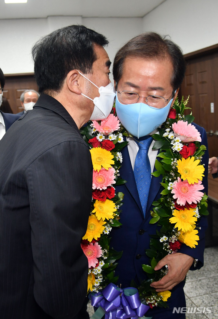 [부산=뉴시스] 하경민 기자 = 홍준표 국민의힘 대선 경선 예비후보가 3일 오전 부산 수영구 부산시당에서 열린 jp희망캠프 부산 선대위 임명장 수여식에 참석, 꽃목걸이를 걸고 행사장에 입장하면서 지지자와 대화하고 있다. 2021.10.03. yulnetphoto@newsis.com