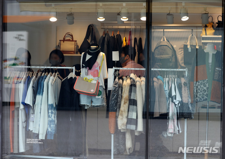 [서울=뉴시스] 백동현 기자 = 추석 대목과 코로나19 상생 국민 지원금 지급으로 소상공인 체감경기지수(BSI)가 상승한 것으로 조사된 4일 오전 서울 성동구 성수동 카페 거리의 한 가게에서 고객들이 옷을 고르고 있다. 2021.10.04. livertrent@newsis.com