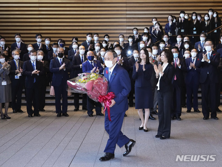 [도쿄/교도·AP=뉴시스] 일본 총리직에서 퇴임한 스가 요시히데(가운데) 일본 총리가 4일 관저 직원들의 박수를 받으며 도쿄 총리관저를 나서고 있다. 2021.10.04. 