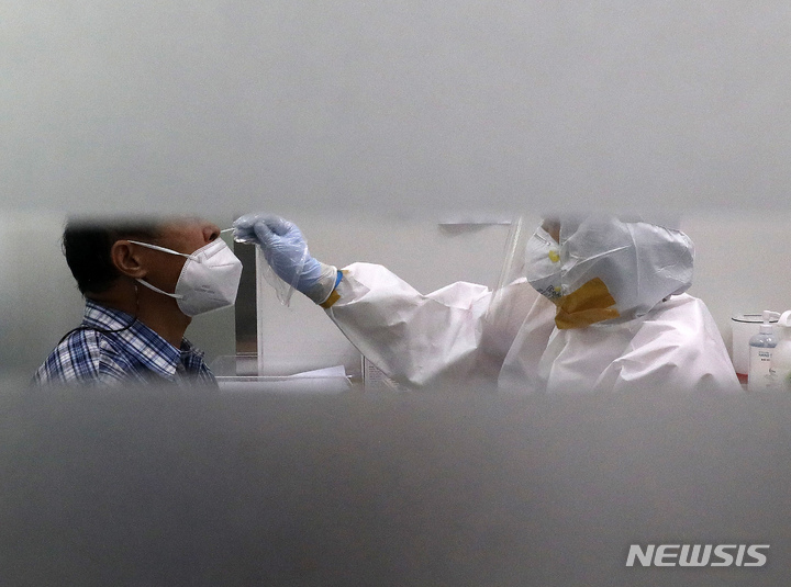 [서울=뉴시스] 백동현 기자 = 지난 5일 오후 서울 마포구보건소 선별진료소에서 의료진이 검체를 채취하고 있다. 2021.10.05. livertrent@newsis.com