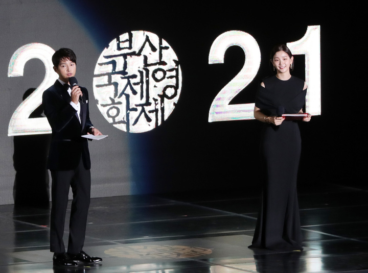 [부산=뉴시스] 하경민 기자 = 제26회 부산국제영화제 개막식이 열린 6일 오후 부산 해운대구 영화의전당 야외극장에서 배우 송중기와 박소담이 사회를 보고 있다. 올해 영화제는 개막작인 임상수 감독의 '행복의 나라로'(Heaven: To the Land of Happiness)를 시작으로 15일까지 영화의전당을 포함한 6개 극장 29개 스크린에서 총 70개국의 작품 223편을 상영한다. 상영작의 관람좌석은 50%만 운영하고, 작품 1편당 2~3회씩 선보인다. 2021.10.06. yulnetphoto@newsis.com