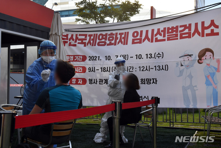 [부산=뉴시스] 하경민 기자 = 제26회 부산국제영화제 기간인 7일 부산 해운대구 영화의전당에 마련된 코로나19 임시선별검사소를 찾은 외국인 등이 진단검사를 위한 검체를 채취하고 있다. 부산시는 7일부터 13일까지 매일 오전 9시~오후 6시 부산국제영화제 임시선별검사소를 운영한다. 2021.10.07. yulnetphoto@newsis.com