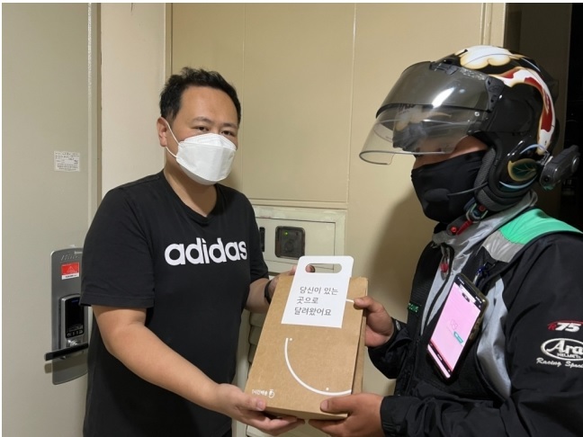 [서울=뉴시스]아이폰13 출시일인 8일 자정에 KT의 ‘미드나잇배송’으로 아이폰13을 직접 전달하고 있는 모습. (사진=KT 제공) 2021.10.08