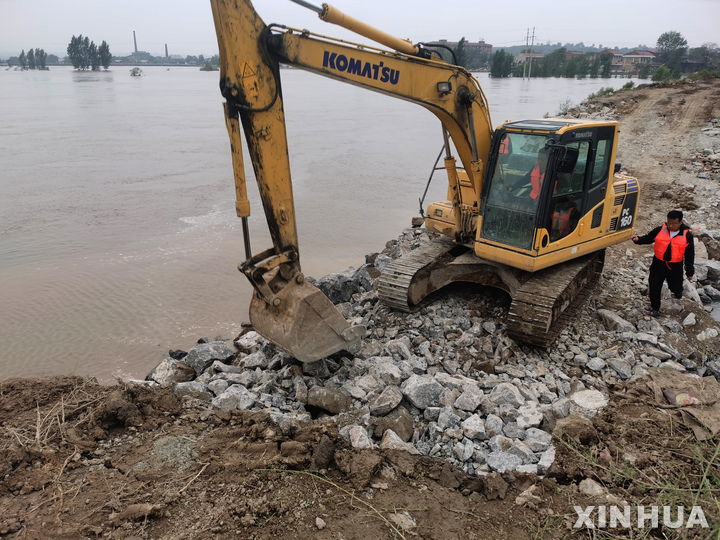[타이위안=신화/뉴시스] 중국 북부 산시성에 연일 내린 폭우로 홍수가 발생한 가운데 8일 굴삭기가 윈청 신장에있는 황허 지류에서 뚫린 제방을 돌과 자갈로 메우는 작업을 하고 있다. 2021.10.10