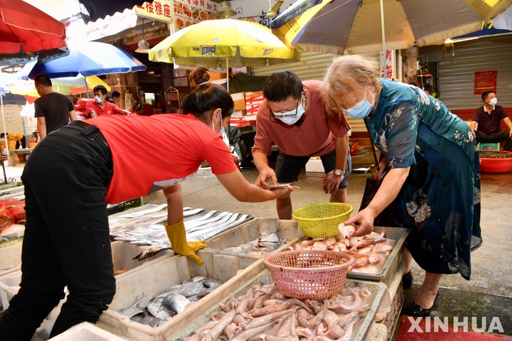 [샤먼=신화/뉴시스] 코로나19 집단발병이 일어났던 중국 푸젠성 샤먼 시내에 있는 수산물 시장을 찾은 시민들이 예방을 위해 마스크를 착용한 채 물건을 고르고 있다. 2021.10.09