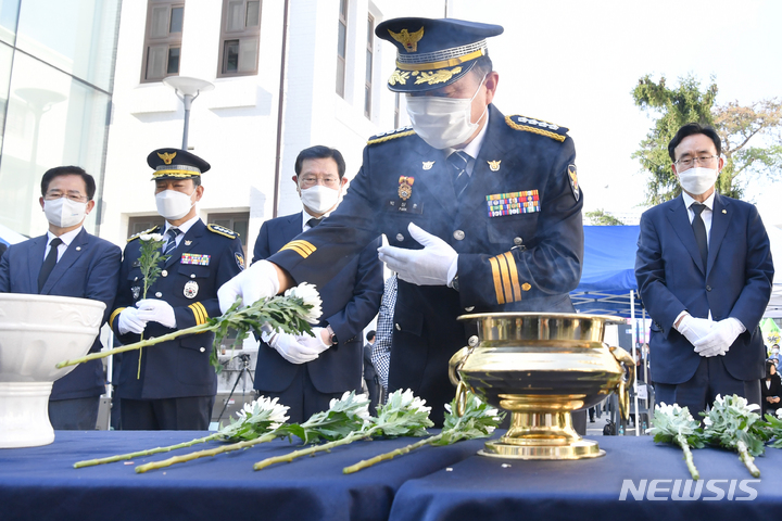 [광주=뉴시스] 변재훈 기자 = 9일 광주 동구 옛 전남도경찰국 건물 일원에서 열린 '민주 경찰 영웅' 안병하 치안감의 33주기 추모식에서 경찰 관계자가 헌화하고 있다. 안 치안감은 5·18민주화운동 당시 신군부의 발포 명령을 거부한 뒤 고초를 겪었으나 역사적 재평가를 통해 민주화운동유공자, 경찰영웅 1호로 선정됐다. 2021.10.09. wisdom21@newsis.com