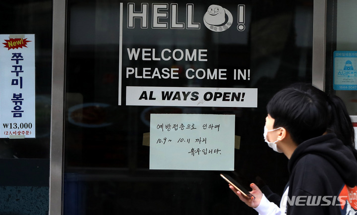 [서울=뉴시스] 추상철 기자 = 코로나19 '백신 패스'를 두고 차별 논란이 이어지고 있는 10일 오전 서울 도심의 한 음식점에는 '예방접종으로 인하야 휴무합니라'라는 안내문이 부착돼 있다. 2021.10.10. scchoo@newsis.com