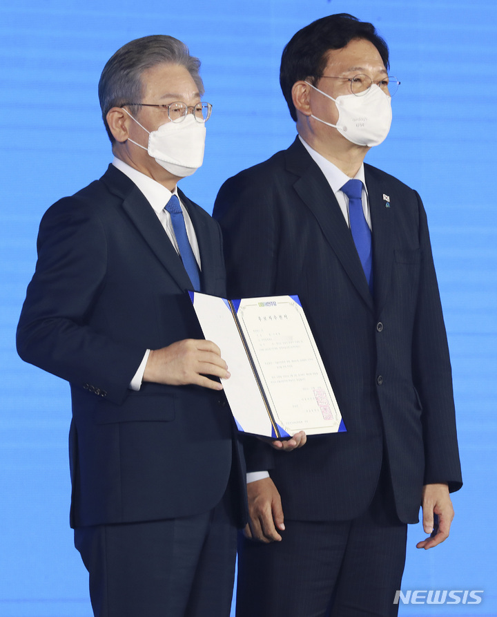 [서울=뉴시스] 국회사진기자단 = 더불어민주당 제20대 대통령 후보에 선출된 이재명 후보가 10일 서울 송파구 올림픽공원 핸드볼경기장에서 열린 서울 합동연설회에서 후보자 추천서를 받은 뒤 송영길 대표와 기념촬영을 하고 있다. 2021.10.10. photo@newsis.com