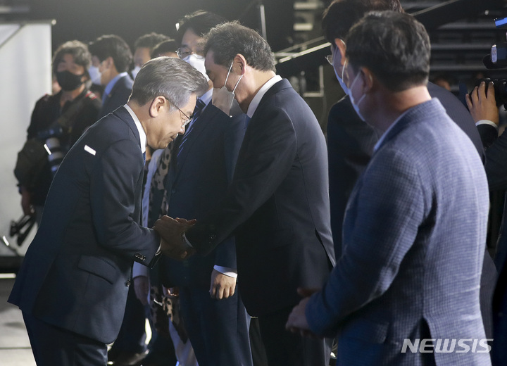 [서울=뉴시스] 국회사진기자단 = 더불어민주당 제20대 대통령 후보에 선출된 이재명 후보가 10일 서울 송파구 올림픽공원 핸드볼경기장에서 열린 서울 합동연설회에서 이낙연 후보와 인사하고 있다. 2021.10.10. photo@newsis.com