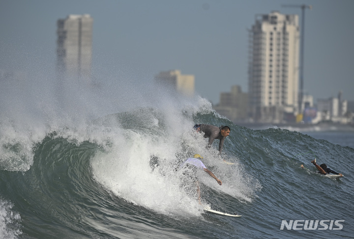 [마사틀란( 멕시코)=AP/뉴시스]멕시코 태평양 연안의 피니토스해수욕장에서 열대성폭풍이 다가 오고 있는데도 서핑에 열중하고 있는 사람들.&nbsp; 미 허리케인 센터는 허리케인 릭이 세력을 키위 태평양연안 휴양지를 강타할 것이라고 23일 예보했다.&nbsp;&nbsp; 