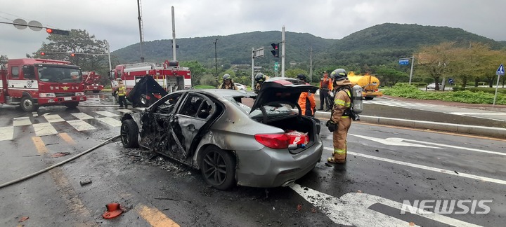 [경주=뉴시스] 이은희 기자= 15일 낮 경주 보문단지 인근 교차로에서 BMW 승용차에 불이 나 소방당국이 진화하고 있다.(사진= 경주소방서 제공) 2021.10.15. photo@newsis.com