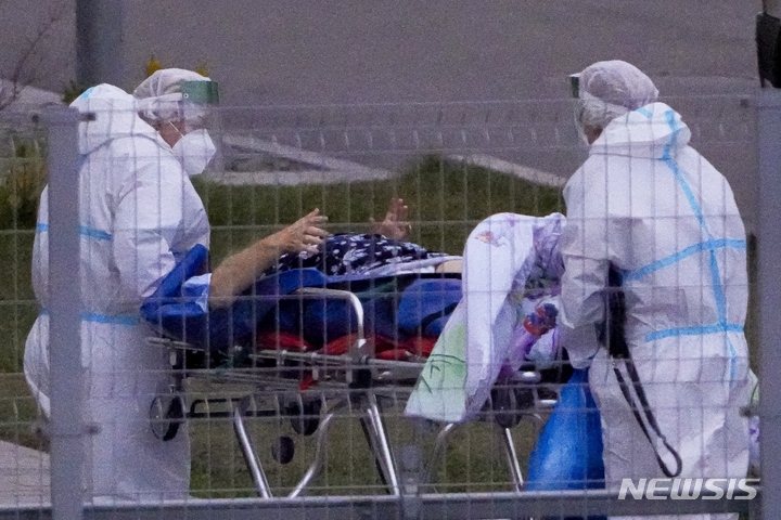[AP/뉴시스] 16일 러시아 모스크바 인근 도시에서 코로나19 의심 환자가 이송되고 있다. 러시아는 16일 하루 동안 전기간 최다수인 3만4300명이 신규 확진되었고 15일에는 기록적인 1002명이 하루에 사망했다.