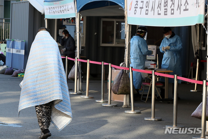 [서울=뉴시스] 백동현 기자 = 지난 17일 오전 서울 중구 서울역광장 임시선별검사소에서 한 시민이 담요를 덮고 있다. 2021.10.17. livertrent@newsis.com