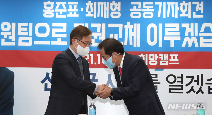 [서울=뉴시스] 국회사진기자단 = 홍준표(오른쪽) 국민의힘 대선 경선 후보와 경선 후보였던 최재형 전 감사원장이 17일 오전 서울 여의도 홍 후보 캠프 사무실에서 열린 기자회견에 앞서 손을 잡고 인사하고 있다.&nbsp; 2021.10.17. photo@newsis.com