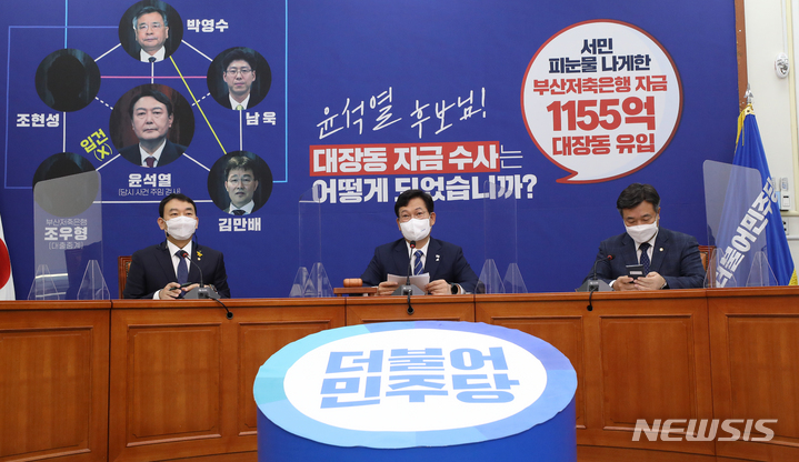 [서울=뉴시스] 전신 기자 = 송영길 더불어민주당 대표와 최고위원들이 18일 서울 여의도 국회에서 열린 최고위원회의에 앞서 대장동 의혹과 관련해 부산저축은행 부실 수사를 지적하는 내용이 담긴 배경판을 바라보며 대화하고 있다. 2021.10.18. photo1006@newsis.com