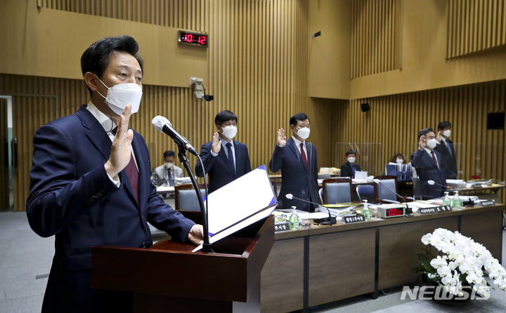 [서울=뉴시스] 국회사진기자단 = 오세훈 서울시장이 20일 서울 중구 서울시청에서 열린 국토교통위원회의 서울시에 대한 국정감사에서 선서하고 있다. 2021.10.20. photo@newsis.com