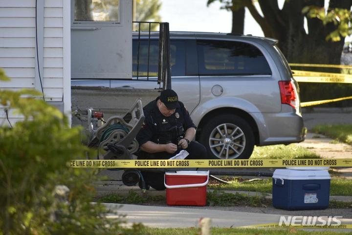 [위스콘신주=AP/뉴시스]미국 위스콘신주 커노샤에서 한 경찰이 2021년 10월20일(현지시간) 밤 늦게 발생한 총격사건을 조사하고 있다. 위스콘신주 남동부의 한 주택에서 총격이 발생해 3명이 숨지고 2명이 중상을 입었다. 2022.12.02