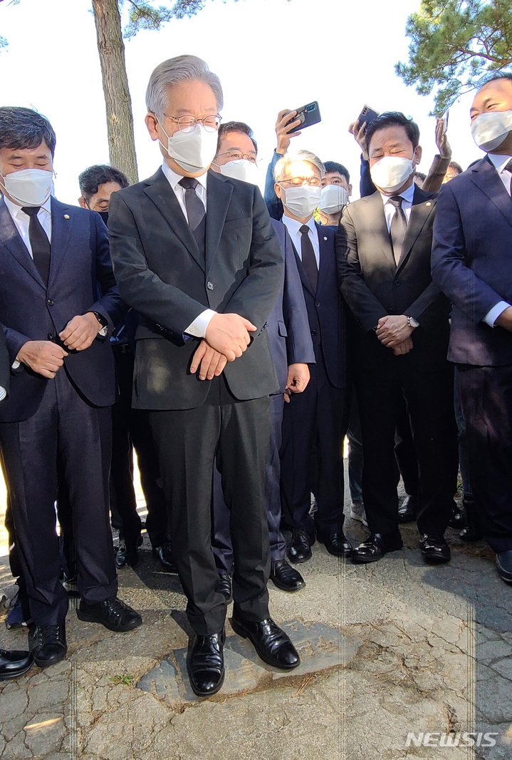 [광주=뉴시스] 류형근 기자 = 더불어민주당 대선 후보인 이재명 경기지사가 22일 오전 광주 북구 민족민주열사묘역(옛 망월묘역) 입구 땅에 박혀 있는 '전두환 기념비'를 밟고 있다. '전두환 기념비'는 1982년 전두환씨의 전남 담양군 방문을 기념해 세워졌던 비석으로, 광주·전남 민주동지회가 비석의 일부를 떼어내 가져와 참배객들이 밟고 지나가도록 설치했다. 2021.10.22. hgryu77@newsis.com