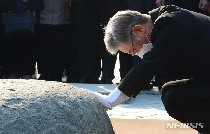 [김해=뉴시스] 차용현 기자 = 더불어민주당 이재명 대선후보가 22일 오후 경남 김해시 봉하마을 고(故) 노무현 전 대통령 묘소에서 너럭바위를 만지고 있다. 2021.10.22. con@newsis.com
