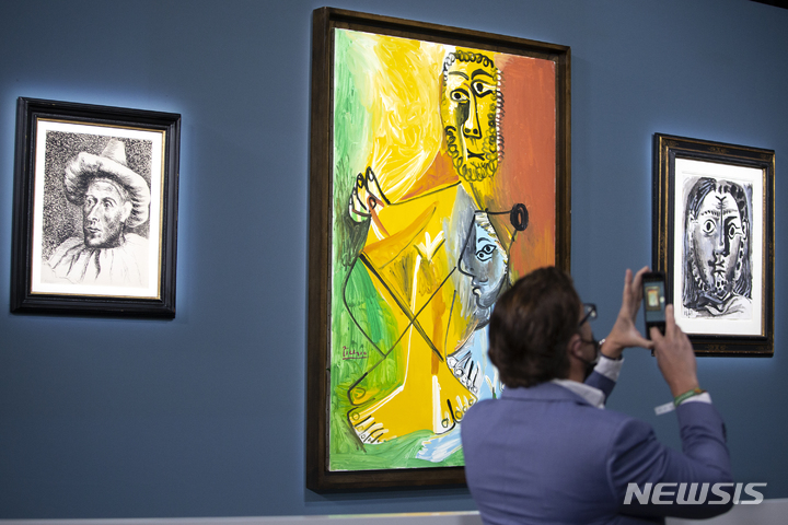 [라스베이거스=AP/뉴시스] 미국 네바다주 라스베이거스 벨라지오 호텔에서 23일 열린 파블로 피카소 작품 경매에 참가한 고객이 전시된 '남자와 아이'를 스마트폰으로 촬영하고 있다. 2021.10.25