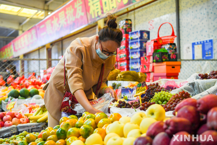 [후허하오터(중국)=Xinhua/뉴시스]10월 24일 중국 내몽골 자치구 후허하오터의 한 도매시장에서 한 주민이 과일을 사고 있다. 2011.11.04
