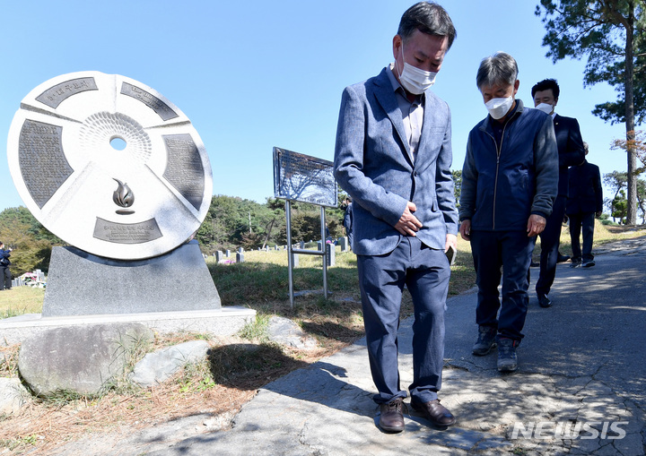 [광주=뉴시스] 변재훈 기자 = 전두환 국립묘지 안장 반대 등 활동을 펼치고 있는 경남 합천 시민사회단체 회원들이 25일 광주 북구 망월동 민족민주열사묘역(옛 망월묘역) 입구 땅에 박혀 있는 '전두환 기념비'를 밟고 있다. '전두환 기념비'는 1982년 전두환씨의 전남 담양군 방문을 기념해 세워졌던 비석으로, 광주·전남 민주동지회가 비석의 일부를 떼어내 가져와 참배객들이 밟고 지나가도록 설치했다. 2021.10.25. wisdom21@newsis.com