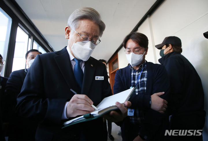 [수원=뉴시스] 국회사진기자단 = 이재명 더불어민주당 대선 후보가 25일 경기도 수원 경기도청에서 도지사 퇴임 기자회견을 마친 후 한 직원에게 사인을 해주고 있다. 2021.10.25. photo@newsis.com