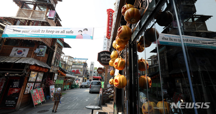 [서울=뉴시스] 추상철 기자 = '위드 코로나'(단계적 일상회복)을 앞두고 이태원 상인들이 핼러윈 데이로 회복 전환에 대한 기대감을 나타내고 있다. 26일 오후 서울 용산구 이태원 거리에서 핼러윈 장식이 된 상점 앞으로 영문으로 된 마스크 착용 현수막이 내걸려 있다. 2021.10.26. scchoo@newsis.com