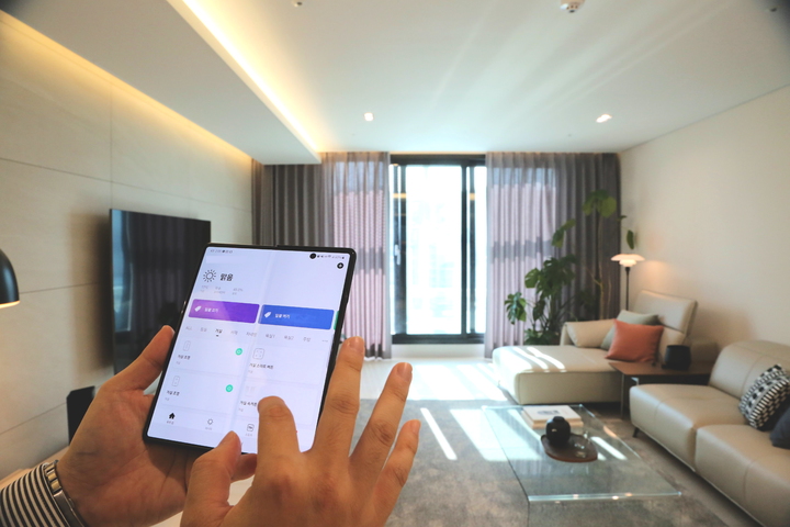 [서울=뉴시스] 한샘리하우스 스마트홈패키지로 꾸며진 모델하우스에서 어플로 스마트기기를 제어하고 있는 모습. 2021.10.27 (사진=한샘 제공) *재판매 및 DB 금지