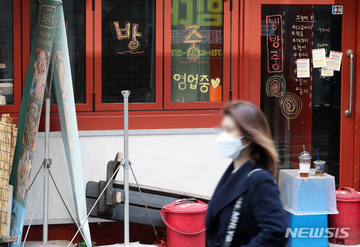 [서울=뉴시스] 백동현 기자 = 한 서울 시민이 폐업한 식당 앞을 지나고 있다. livertrent@newsis.com