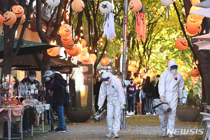 [용인=뉴시스] 김종택기자 = 핼러윈데이를 나흘 앞둔 27일 오후 경기도 용인시 보정동 카페거리에서 기흥구보건소 관계자들이 코로나19 예방을 위해 방역소독을 하고 있다. 2021.10.27. jtk@newsis.com