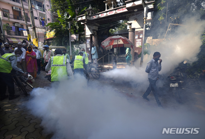 [뉴델리=AP/뉴시스]지난해 10월27일(현지시간) 인도 뉴델리의 한 인구 밀집 지역에서 시청 소속 근로자들이 모기를 잡기 위해 훈증 소독하고 있다. 2021.10.27.