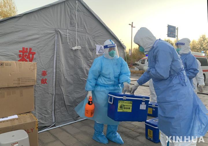 [어지나=신화/뉴시스] 중국 네이멍구 자치구에서 최근 코로나19가 급속도로 퍼지는 가운데 28일 어지나(額濟納) 기(旗) 검사센터에 배치된 보건위생 관계자들이 핵산검사 샘플을 옮기고 있다. 2021.10.30 