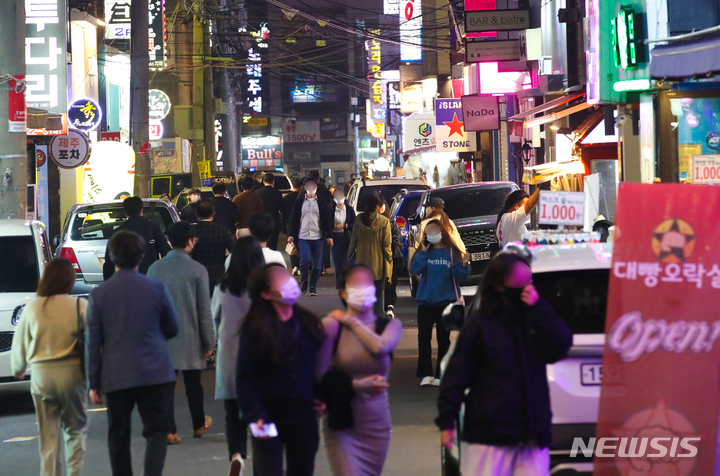[제주=뉴시스] 우장호 기자 = 단계적 일상회복(위드 코로나) 시행 첫날인 1일 제주시청 인근 대학로가 지나는 사람들로 활기를 띠고 있다. 1단계 시행으로 수도권은 10명, 비수도권은 12명까지 모일 수 있으며 식당과 카페 등 대부분 시설은 24시간 영업을 할 수 있다. 2021.11.01. woo1223@newsis.com