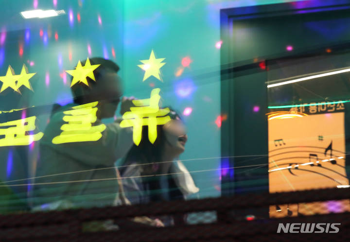 [제주=뉴시스] 우장호 기자 = 단계적 일상회복(위드 코로나) 시행 첫날인 1일 오후 제주시청 인근 대학로의 노래방에서 손님들이 즐거운 시간을 보내고 있다. 1단계 시행으로 수도권은 10명, 비수도권은 12명까지 모일 수 있으며 식당과 카페 등 대부분 시설은 24시간 영업을 할 수 있다. 2021.11.01. woo1223@newsis.com