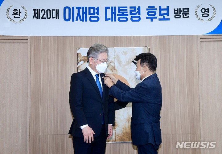 [서울=뉴시스] 국회사진기자단 = 이재명 더불어민주당 대선 후보가 1일 서울 여의도 광복회를 방문해 김원웅 회장으로부터 배지를 받고 있다. 2021.11.01. photo@newsis.com