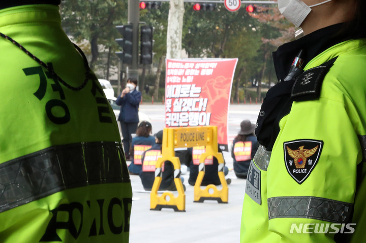 [서울=뉴시스] 백동현 기자 = 단계적 일상회복(위드 코로나) 방역체계가 시작한 지난 1일 오후 서울 영등포구 KB국민은행 신관 앞에서 경찰이 민주노총 집회를 지켜보고 있다. 이날부터 집회와 행사는 코로나19 백신 접종 여부와 상관 없이 100명 미만까지, 접종 완료자 등으로만 구성되면 500명 미만까지 참여 가능하다. 2021.11.01. livertrent@newsis.com