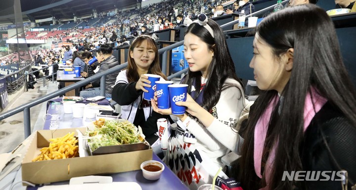 [서울=뉴시스] 김선웅 기자 = 단계적 일상회복 1단계가 시작된 1일 오후 서울 송파구 잠실야구장에서 열린 2021 KBO 포스트시즌 와일드카드 결정 1차전 키움 히어로즈와 두산 베어스의 경기, 관중들이 치맥을 하며 경기를 관람하고 있다. 2021.11.01.  mangusta@newsis.com